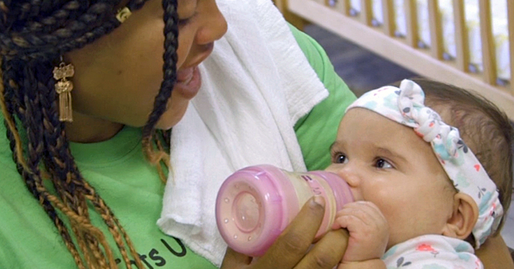 caregiver talks with baby while feeding